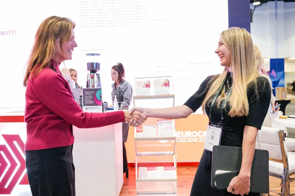 Attendees engaging with sponsors at a booth display at NEI Spring Congress